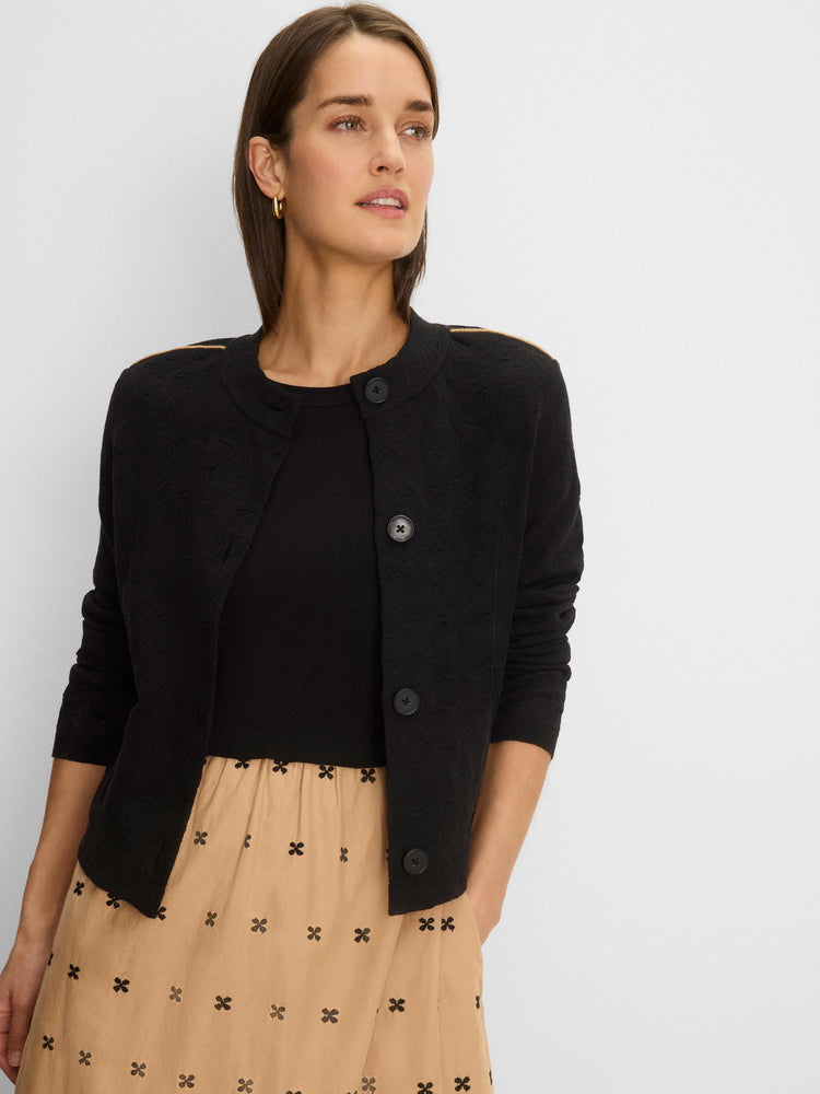 Black knit jacket with geometric texture & tan piping along shoulders. Round neck, black buttons.