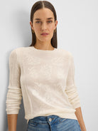 Cream long-sleeved, round-neck sweater with a subtle jacquard lace pattern.