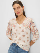 Cream V-neck sweater with pink, blue, and beige paisley pattern.