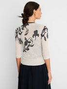 Off-white cardigan with dark ink-style floral pattern on back and 3/4 sleeves.
