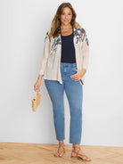 Light beige open cardigan with navy blue floral pattern on shoulders and front.