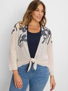 Light beige open cardigan with dark blue floral pattern, shown tied at the front.