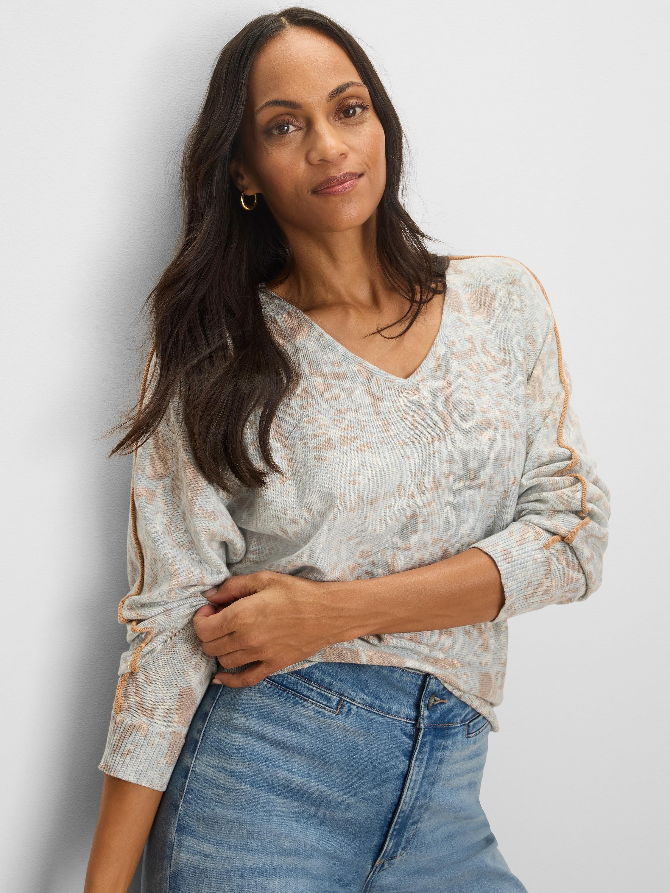 Light gray V-neck sweater with a tan abstract pattern and caramel tipping along the shoulder and sleeve seams.