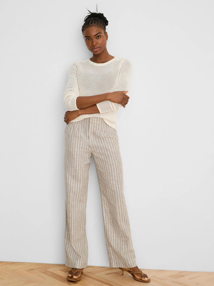 Cream open-knit sweater with a crew neck and long sleeves.