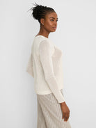 Cream mesh sweater with long sleeves and ribbed cuffs, hem, and neckline.