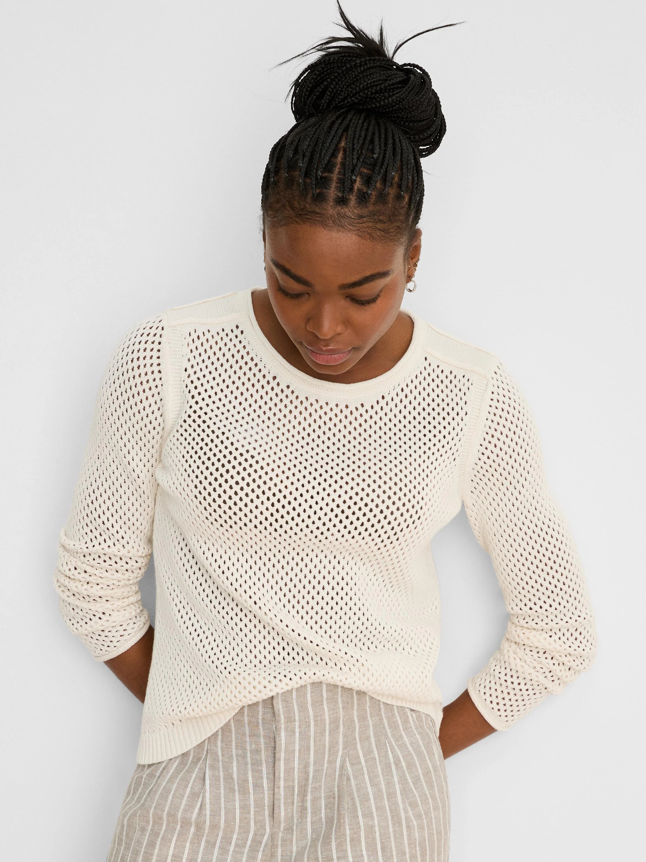 Off-white open knit mesh sweater with a crew neck, long sleeves, and ribbed trim.