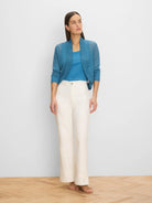 Teal blue open-front bolero cardigan with a ribbed wide collar and ribbed cuffs on its long sleeves.