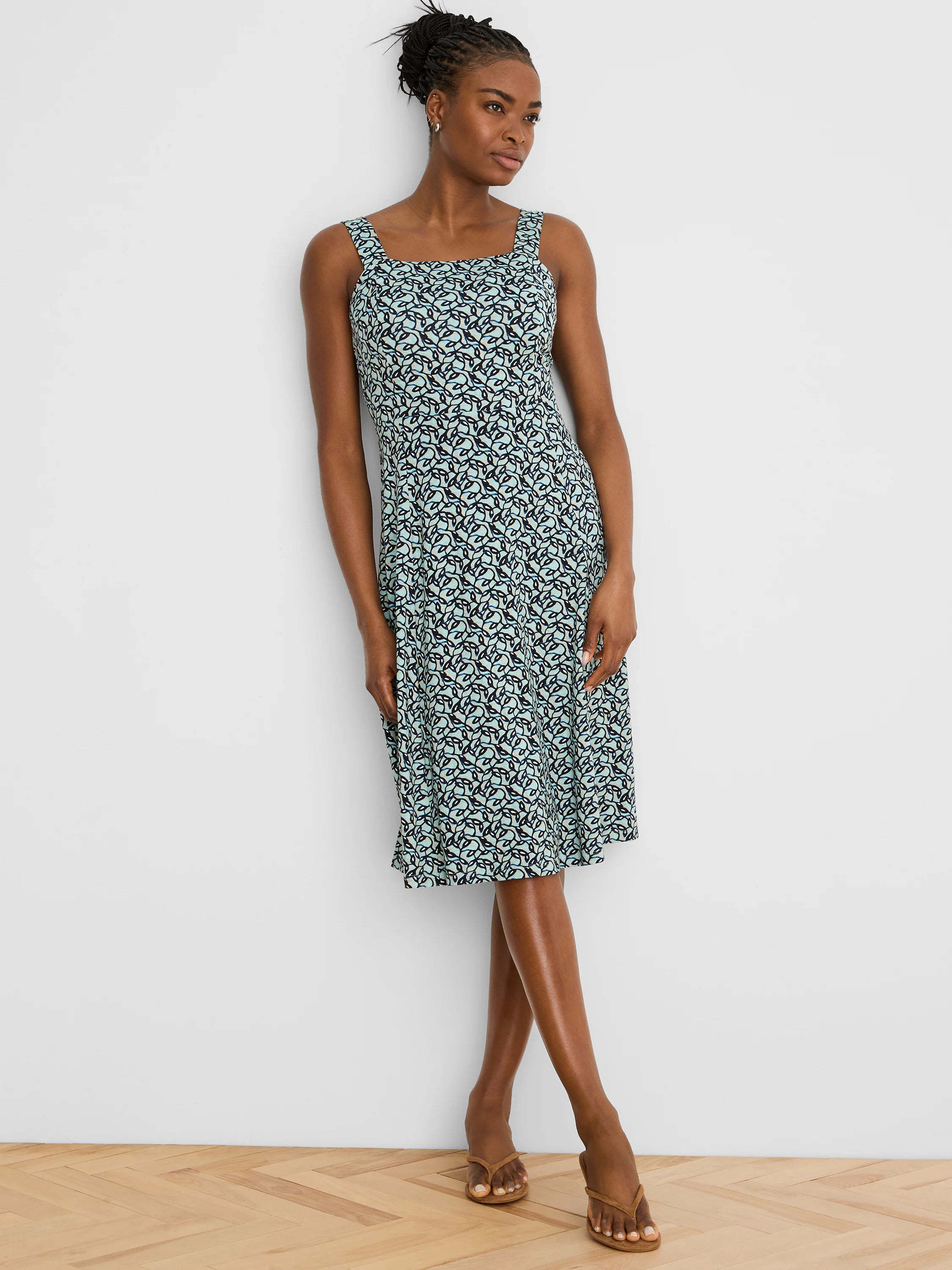 Sleeveless square-neck dress with an aqua and dark blue interlocking leaf pattern, midi length.