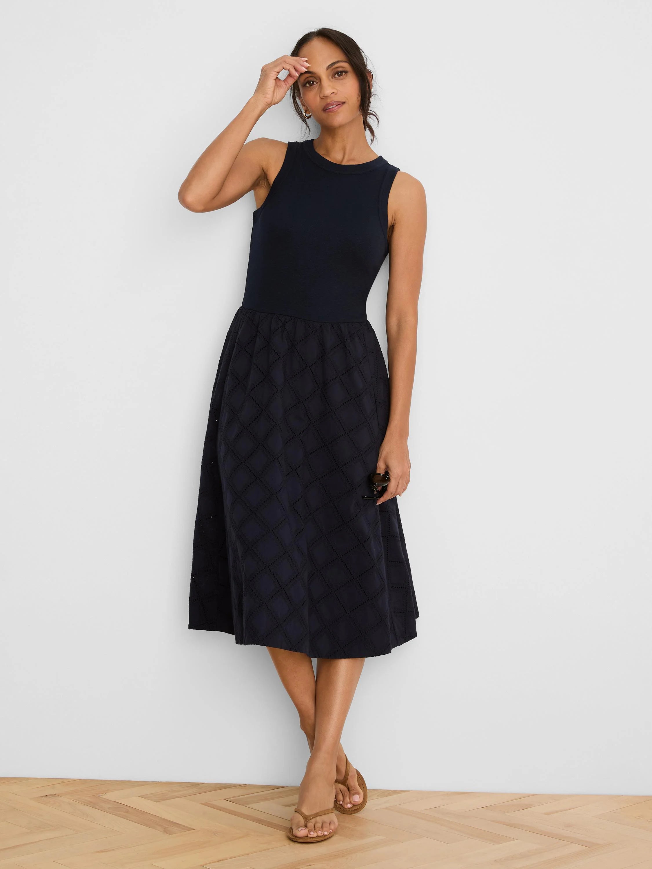 Navy sleeveless midi dress with a ribbed bodice and a skirt featuring diamond eyelet patterns.