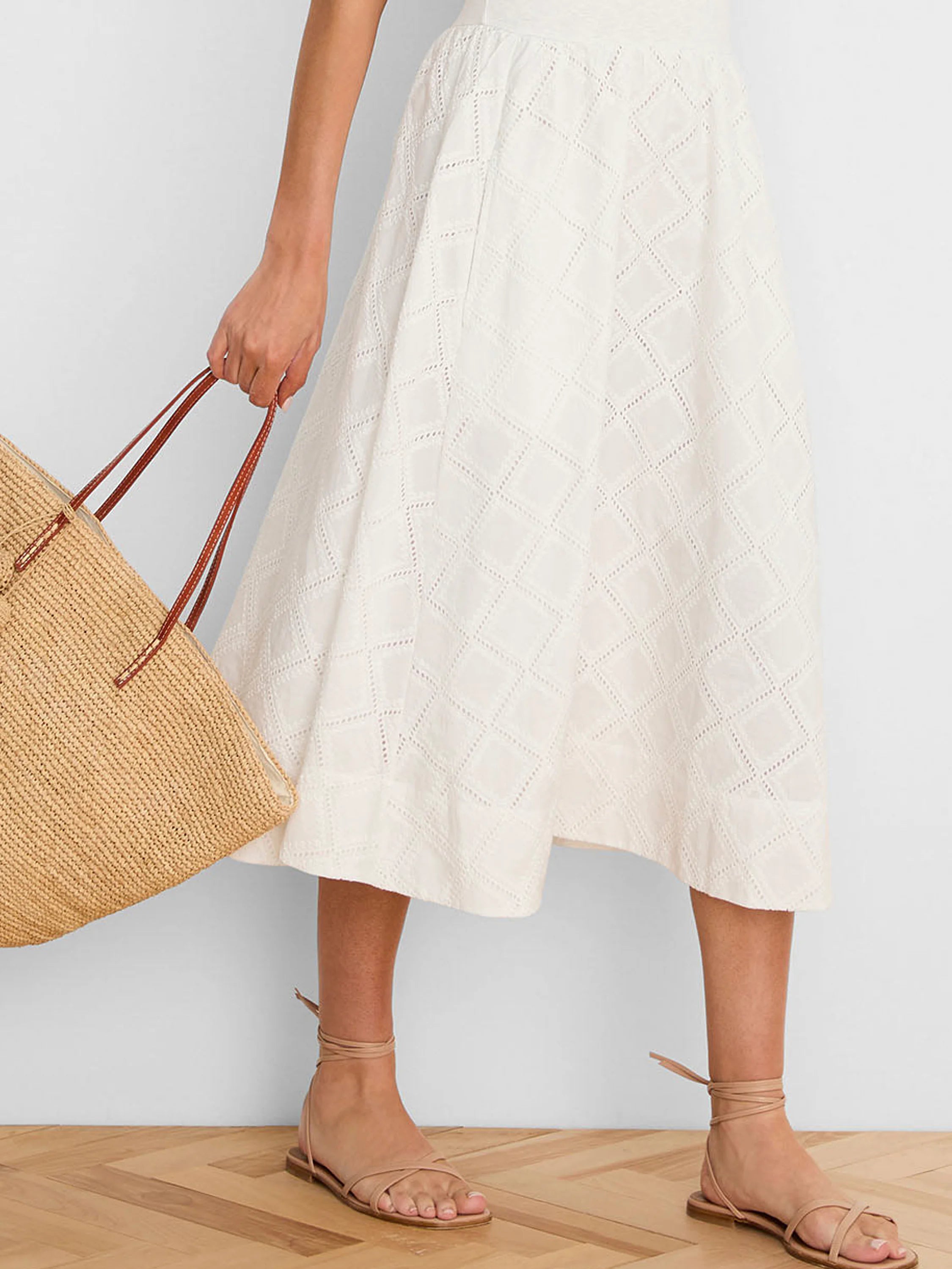 Off-white flowing midi dress with a textured diamond eyelet pattern.