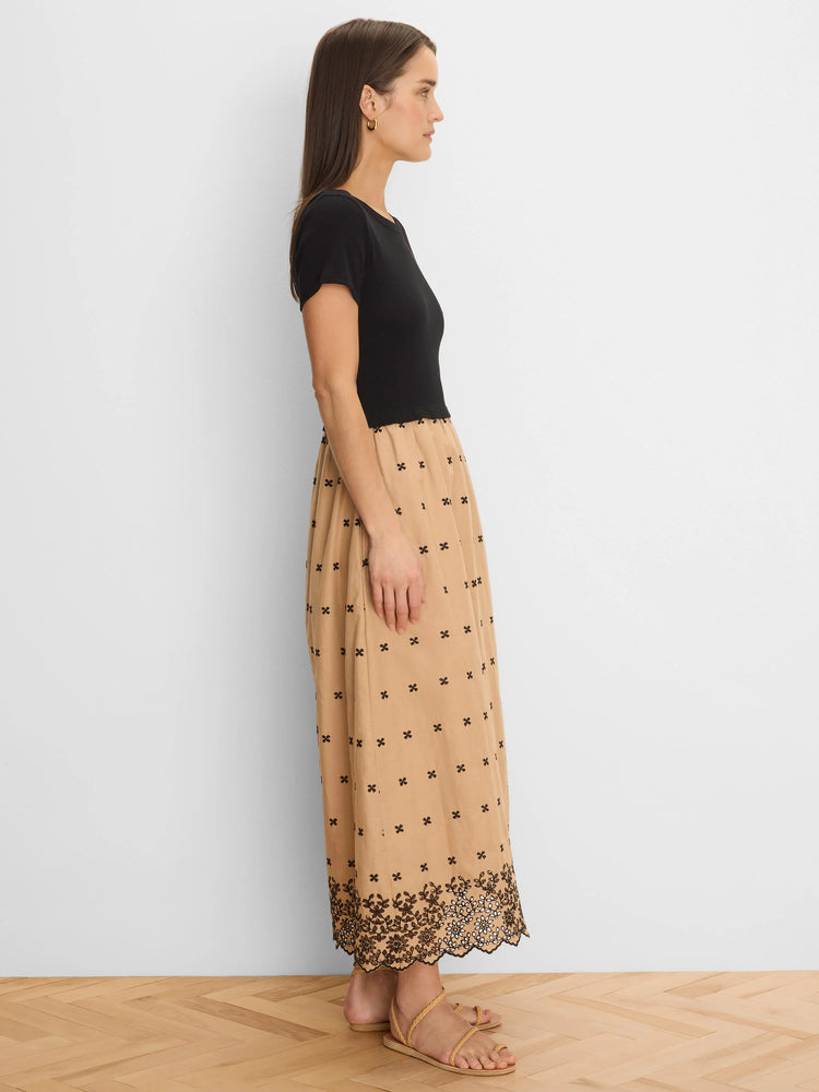 Black top, tan dress with scattered black embroidery and a scalloped floral embroidered hem.