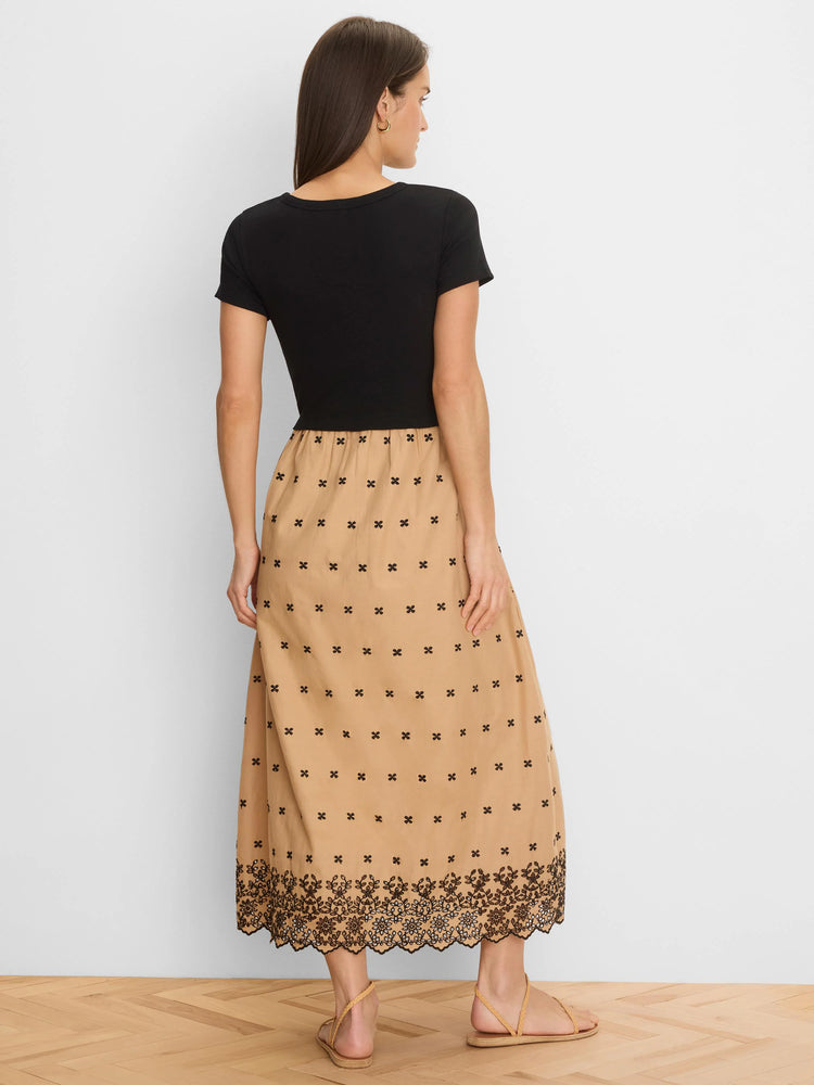Black top, tan midi dress with scattered black clover embroidery, and a wide black floral embroidered hem.