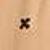 Smooth, warm beige textile, centered with a blurry dark brown X-shape on a faint light textured p...
