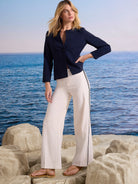 Off-white wide-leg pants with black piping down the outer seams.