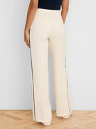 Cream wide-leg pants with navy vertical piping down the outer seams. Model shown from the back.