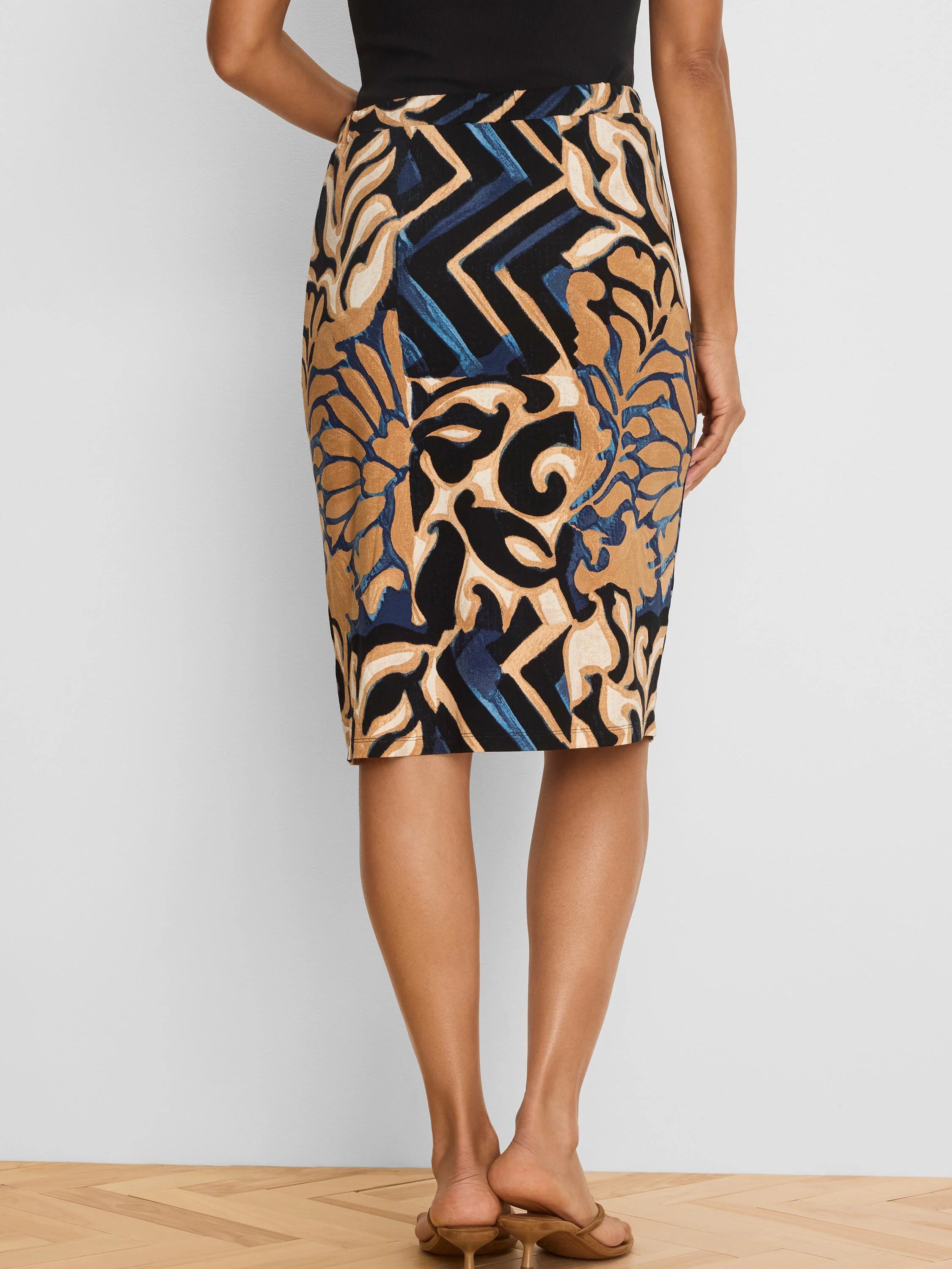Black knit pencil skirt with tan, cream, and blue abstract pattern featuring fluid shapes and zigzags.