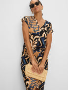 Fitted knit skirt with abstract tan, dark blue, and black 'Deco Blooms' pattern.