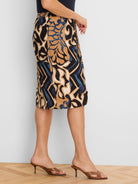 Black knit skirt with knee-length hem, detailed with swirling abstract tan, cream, and blue patterns.