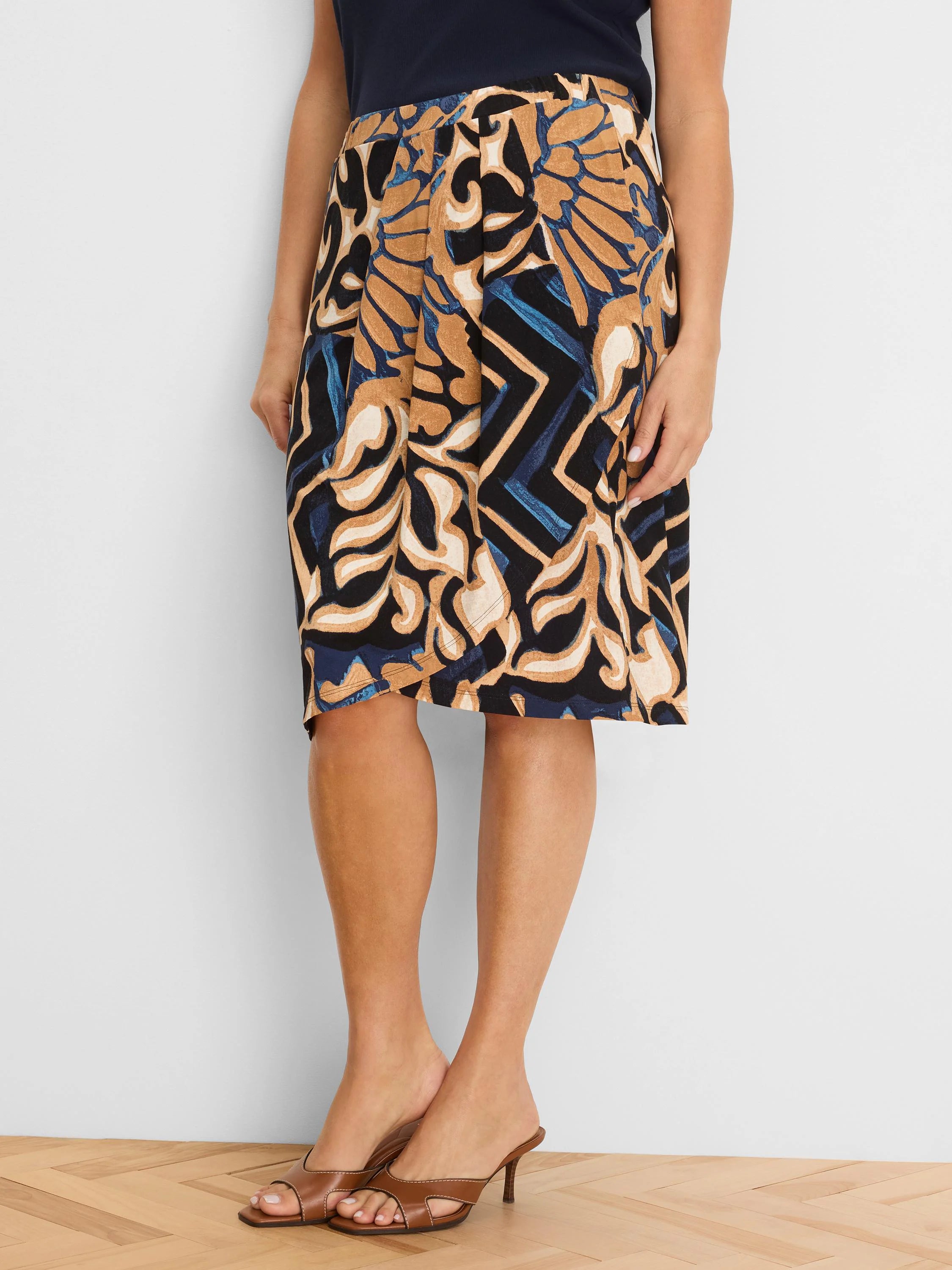 Knit midi skirt with an abstract pattern in black, tan, blue, and cream.