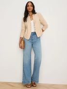 Light beige linen jacket, collarless with split neckline & single row of small brown buttons. Sleeves are rolled.