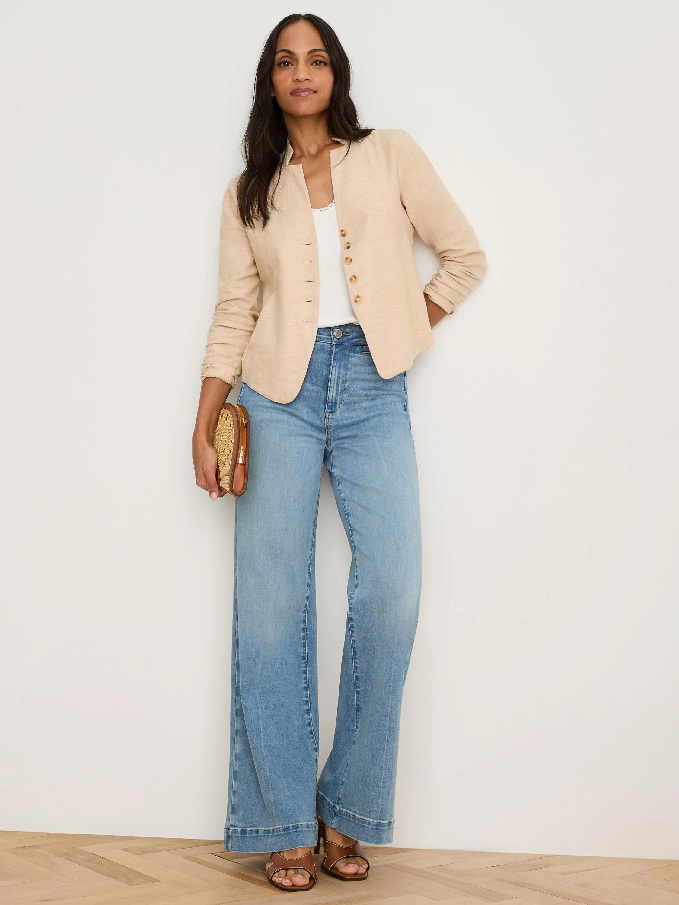 Light beige linen jacket, collarless with split neckline & single row of small brown buttons. Sleeves are rolled.