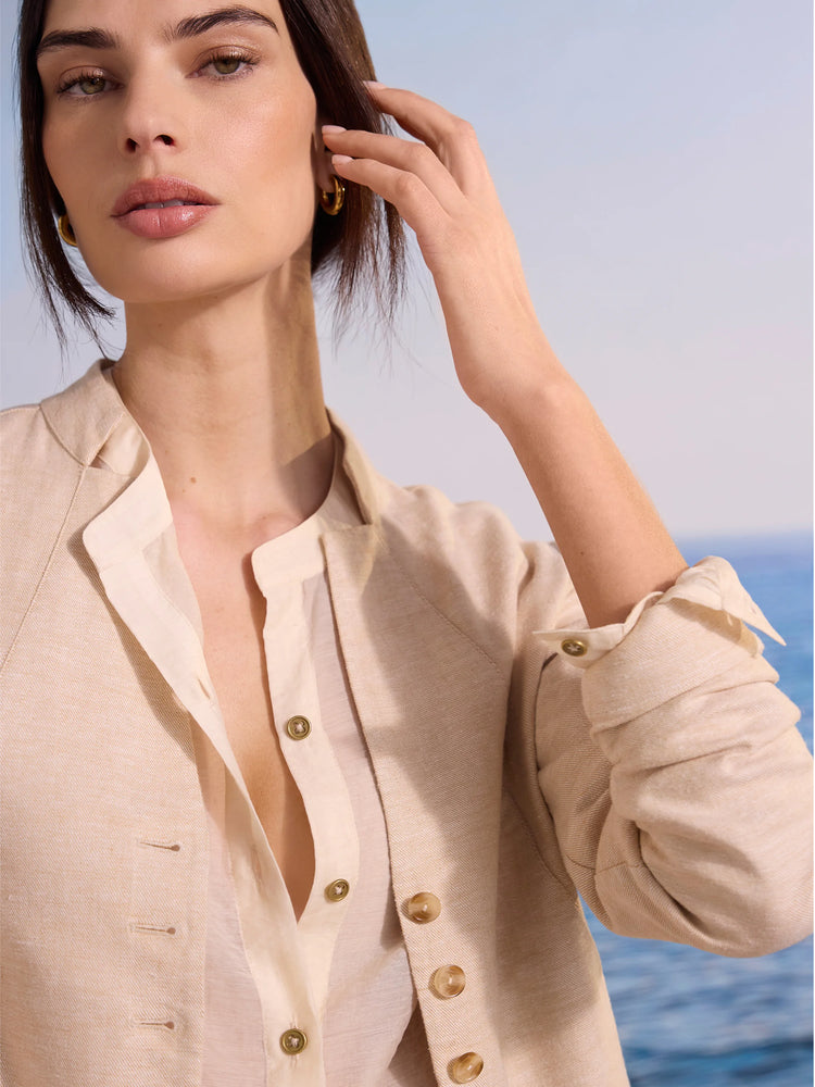 Light tan linen jacket with a band collar, brown buttons, and folded cuffs.