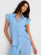 Light blue gauze resort shirt with white vertical stripes, collar, button-front, and cuffed short sleeves.