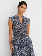 Navy and off-white leopard sketch smocked top with ruffled cap sleeves, stand collar with V-neck, and tiered hem.