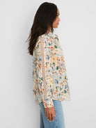 Cream shirt with muted blue, green, orange floral print & ladder lace trim down the sleeve.
