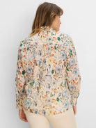 Back of a long-sleeved, light cream shirt with a multi-color floral pattern in blues, greens, and oranges.