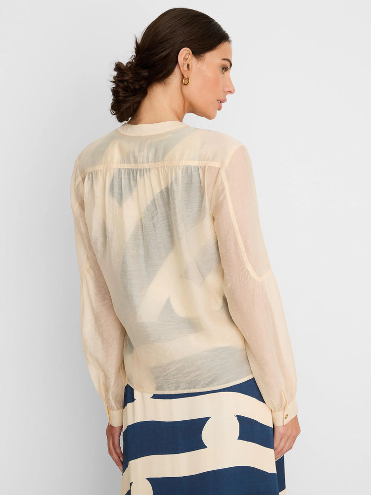 Pale cream sheer long-sleeve shirt with gathered back yoke and buttoned cuffs.