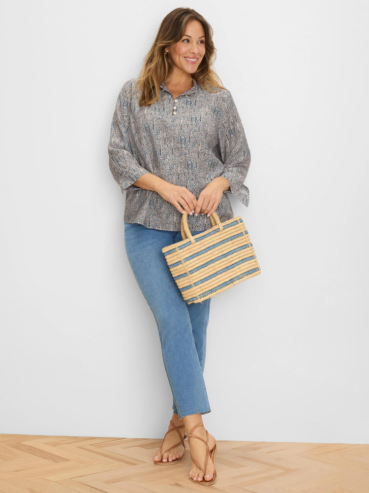 Light beige top with blue and grey speckle pattern. Ruffle neck with buttons, 3/4 length flared sleeves.