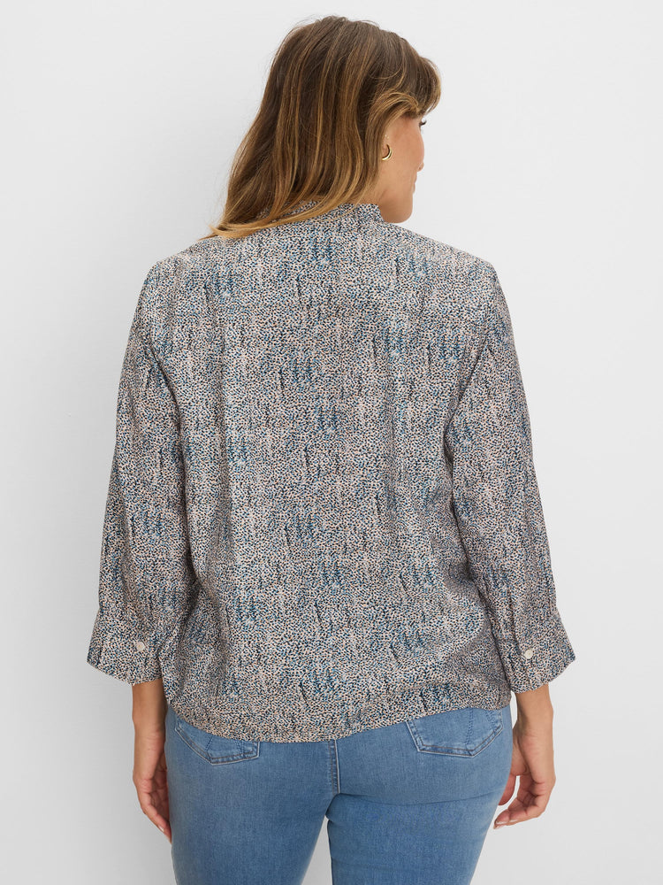 Loose speckled top in muted blue, black, & peach on light fabric with 3/4 length rolled-up sleeves.