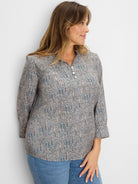 Cream top with blue, brown, black speckles. Ruffled neck, 3-button placket, 3/4 cuffed sleeves.
