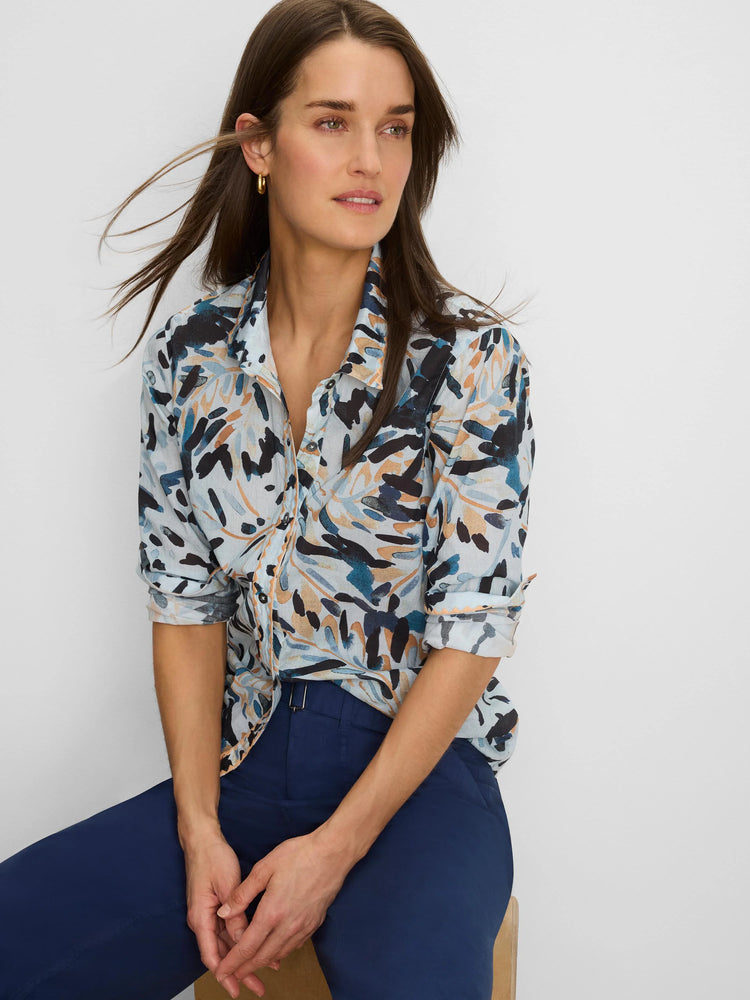 Light blue button-down shirt with abstract navy, teal, and tan brushstroke pattern. Sleeves are rolled up.