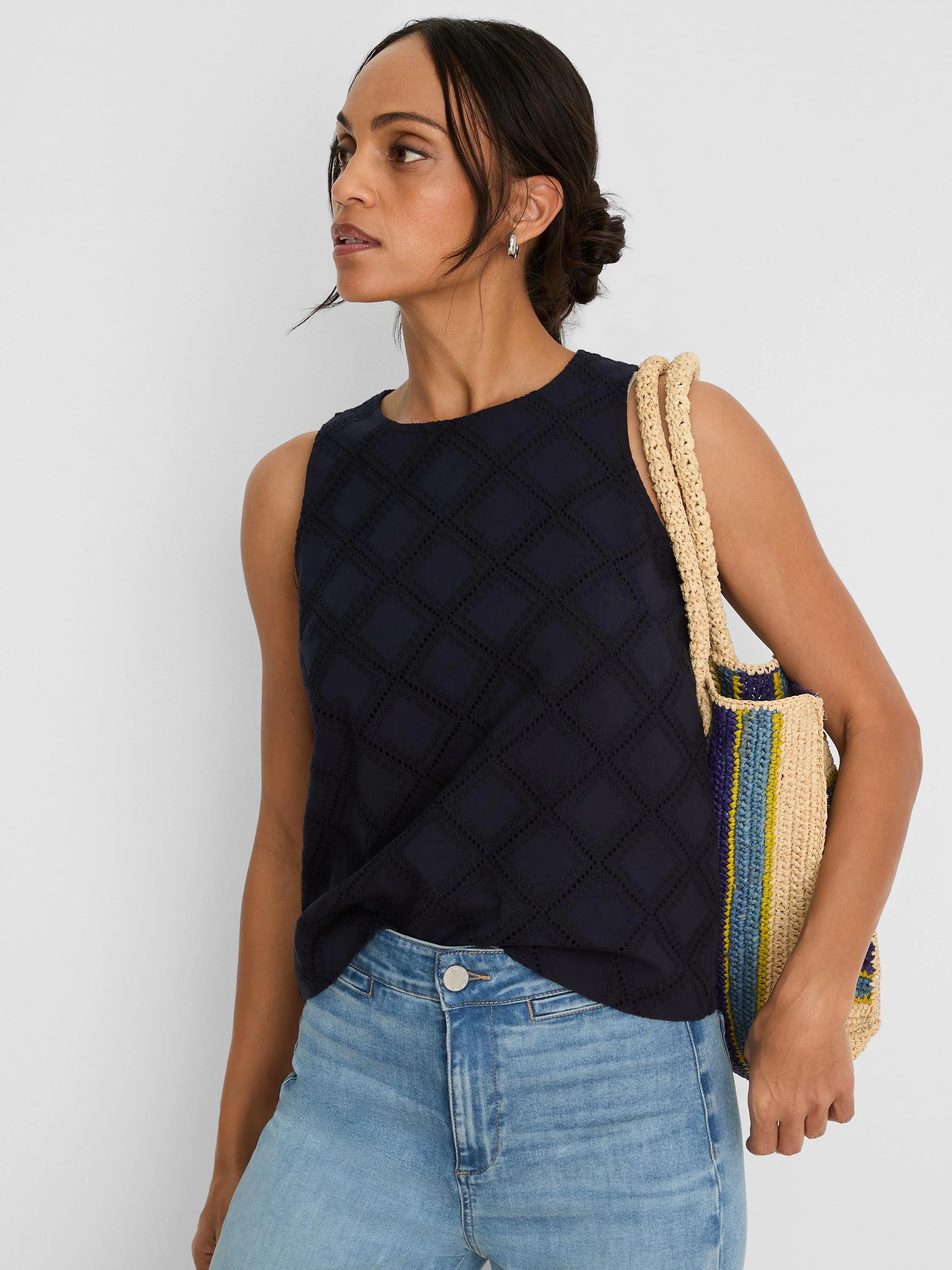 Navy blue sleeveless top with a round neck and diamond eyelet pattern.