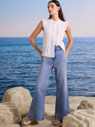 White sleeveless top with frilled shoulders and vertical lace-trimmed pintucks on the front.