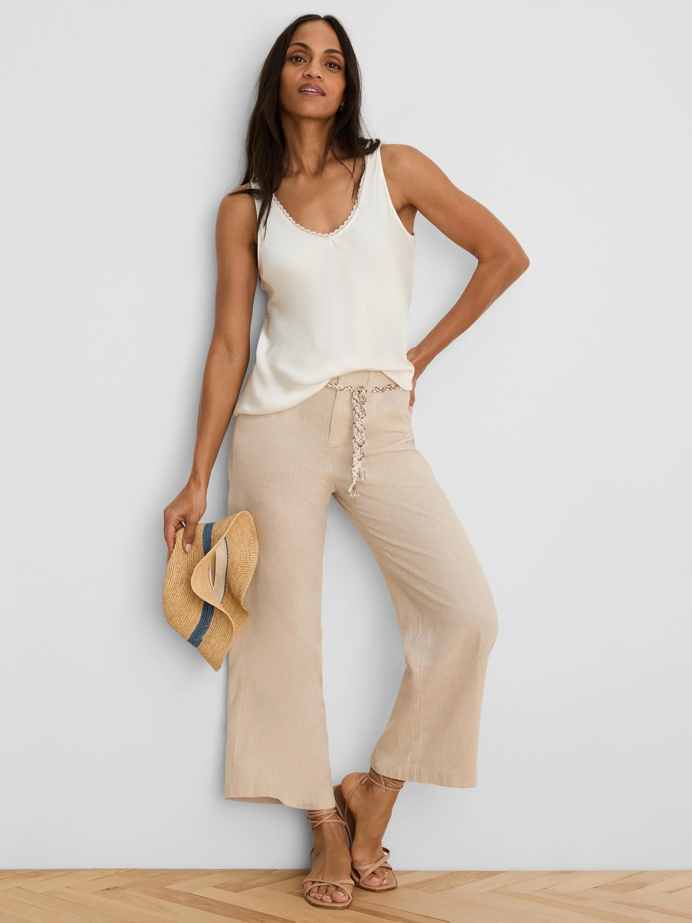 Cream V-neck tank with lace trim, featuring a smooth, glossy finish.