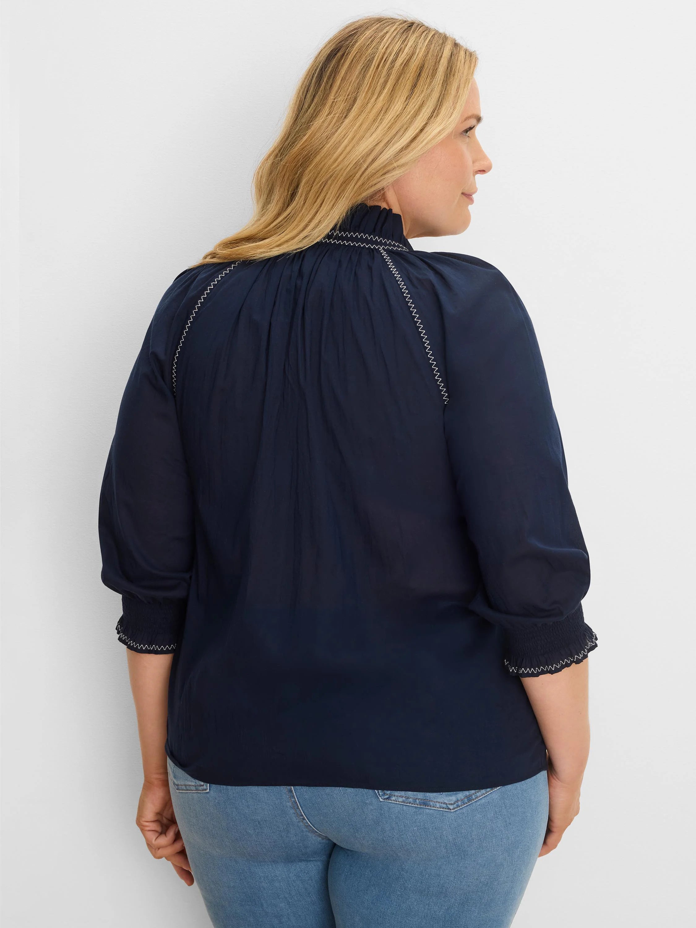 Navy blue cotton crinkle shirt with white zig-zag stitching on shirred mock neck and 3/4 cuffs.