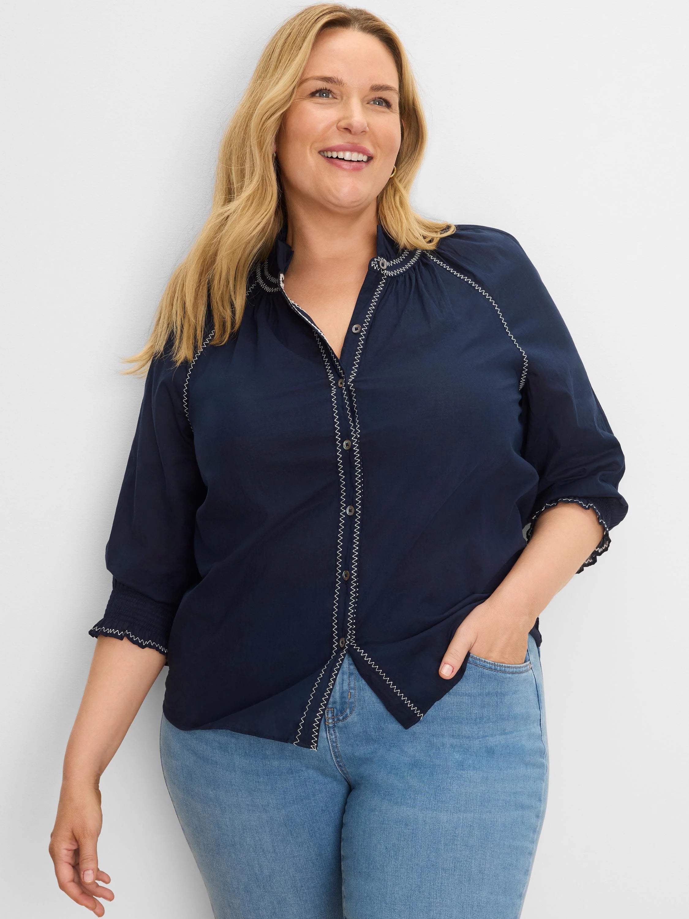 Navy blue cotton crinkle shirt with white zig-zag stitching on button placket, stand collar, and smocked cuffs.