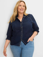 Navy blue cotton crinkle shirt with white zig-zag stitching on button placket, stand collar, and smocked cuffs.