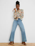 Cream blouse with multi-color pressed flower pattern in blue, green, orange, pink. Band collar, gathered sleeves.