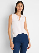 Off-white sleeveless V-neck top with a collared placket.