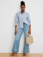 White long-sleeve shirt with blue embroidered tile pattern, ruffled collar, and smocked cuffs.