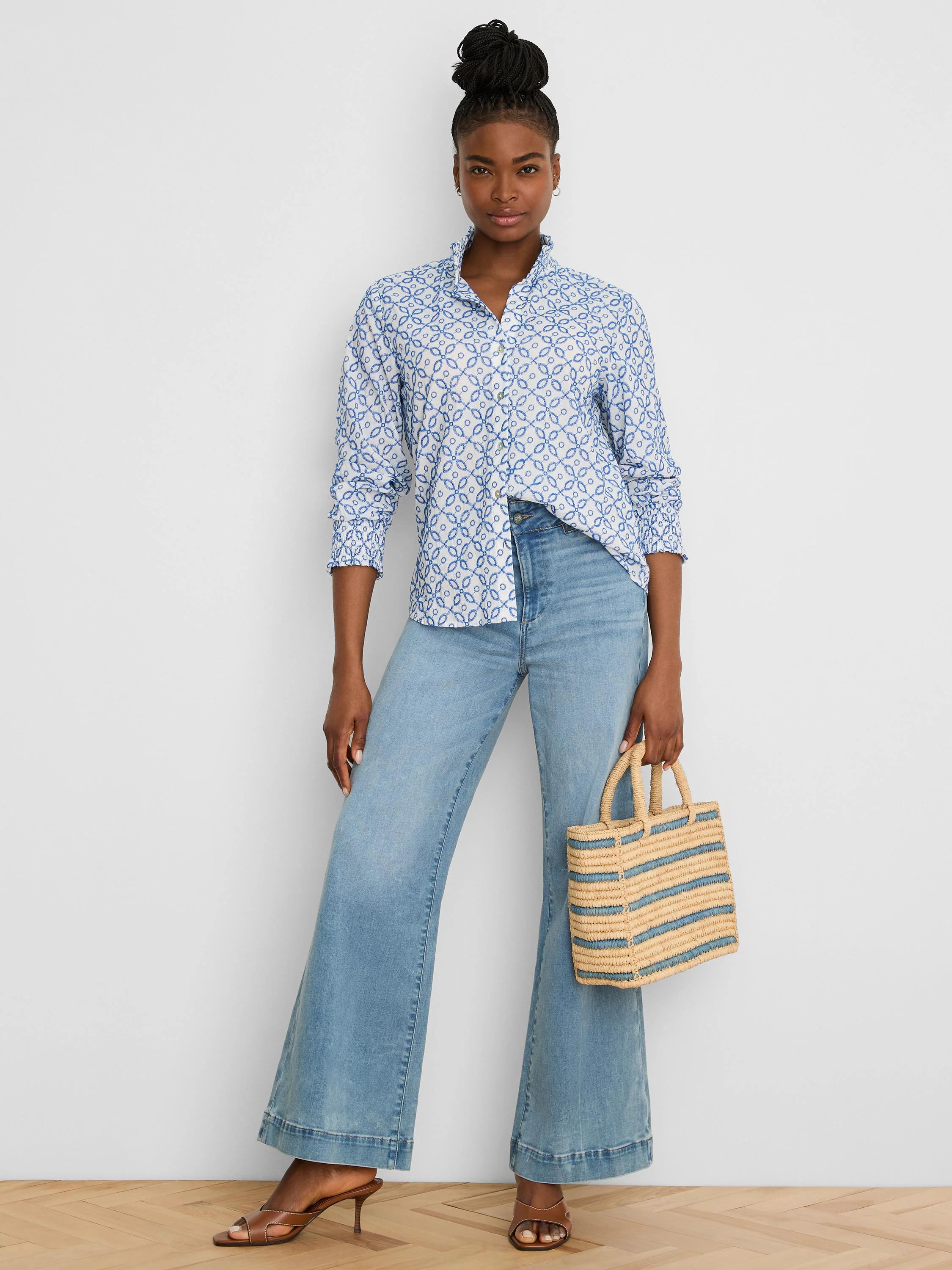 White long-sleeve shirt with blue embroidered tile pattern, ruffled collar, and smocked cuffs.