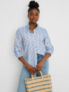 White shirt with blue embroidered tile pattern, ruffled stand-up collar, and smocked cuffs.