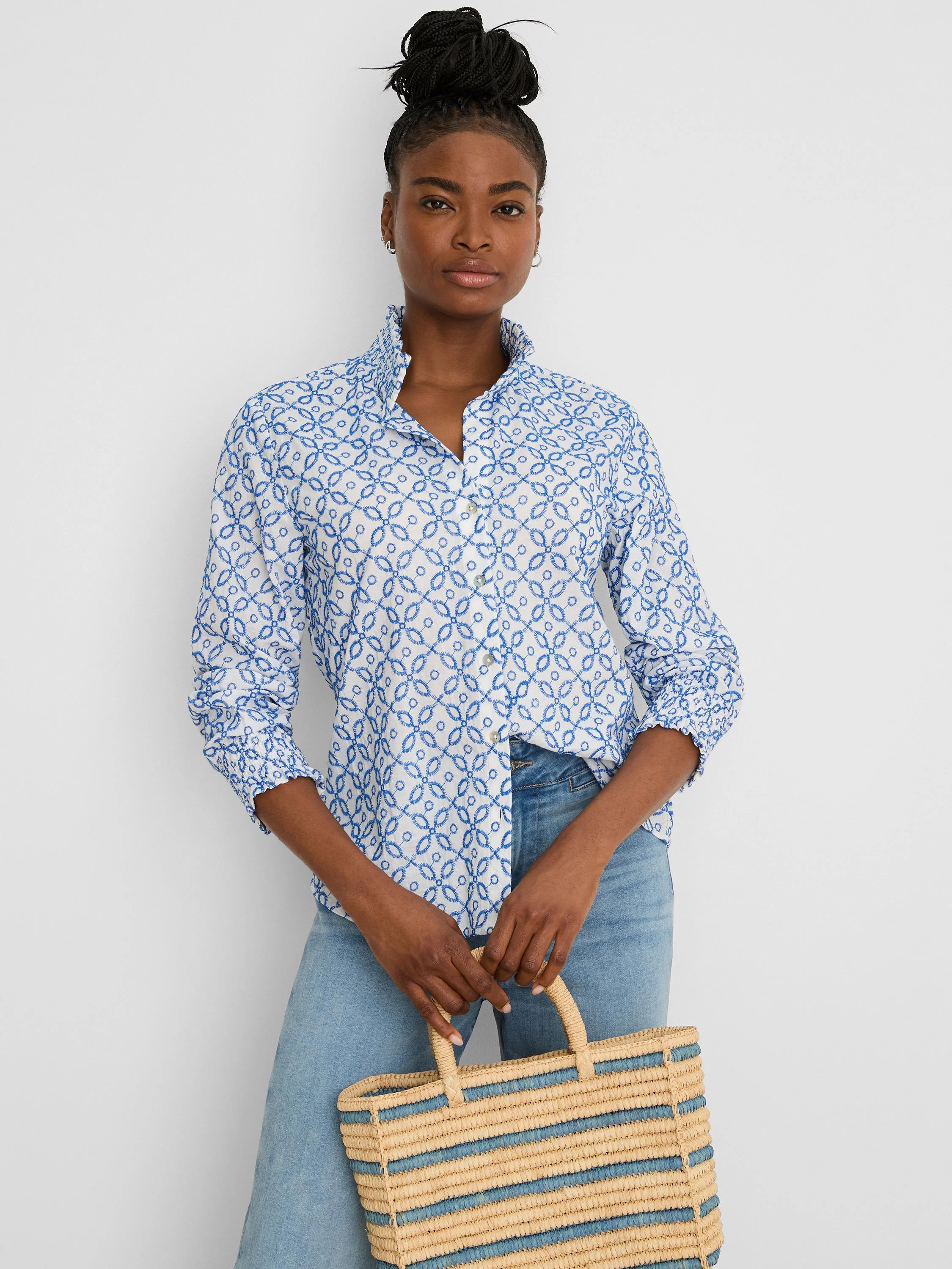 White shirt with blue embroidered tile pattern, ruffled stand-up collar, and smocked cuffs.