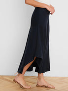 Long dark navy linen skirt with a flowing silhouette, featuring an asymmetrical ruffled high-low hem.