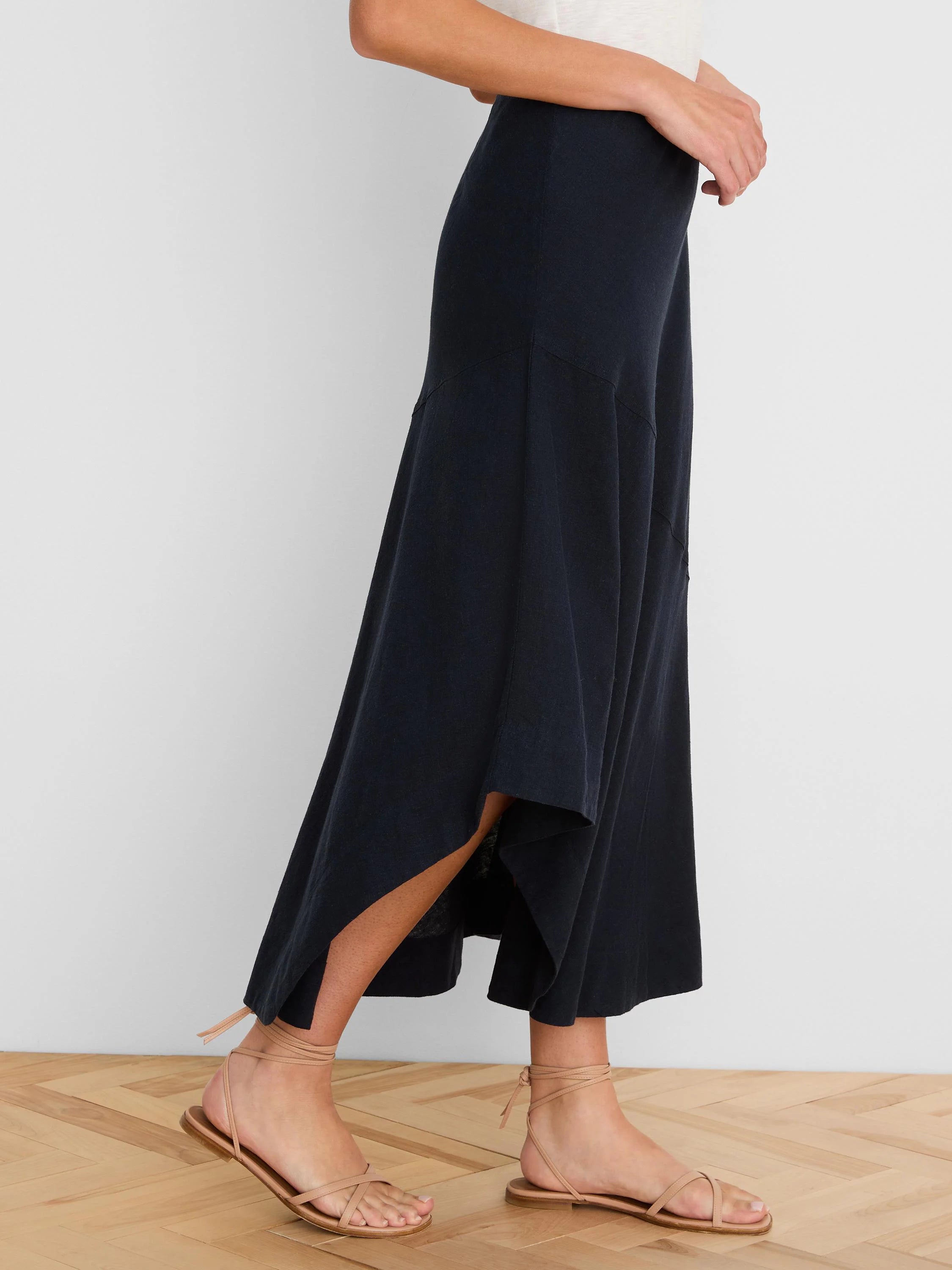 Long dark navy linen skirt with a flowing silhouette, featuring an asymmetrical ruffled high-low hem.