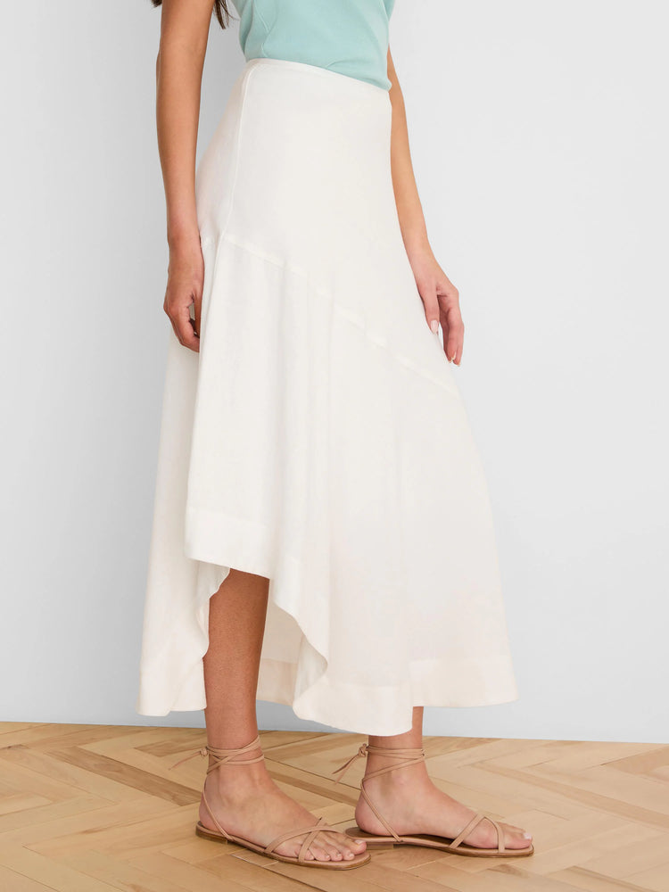 Off-white linen skirt with an asymmetrical, flowing hemline.